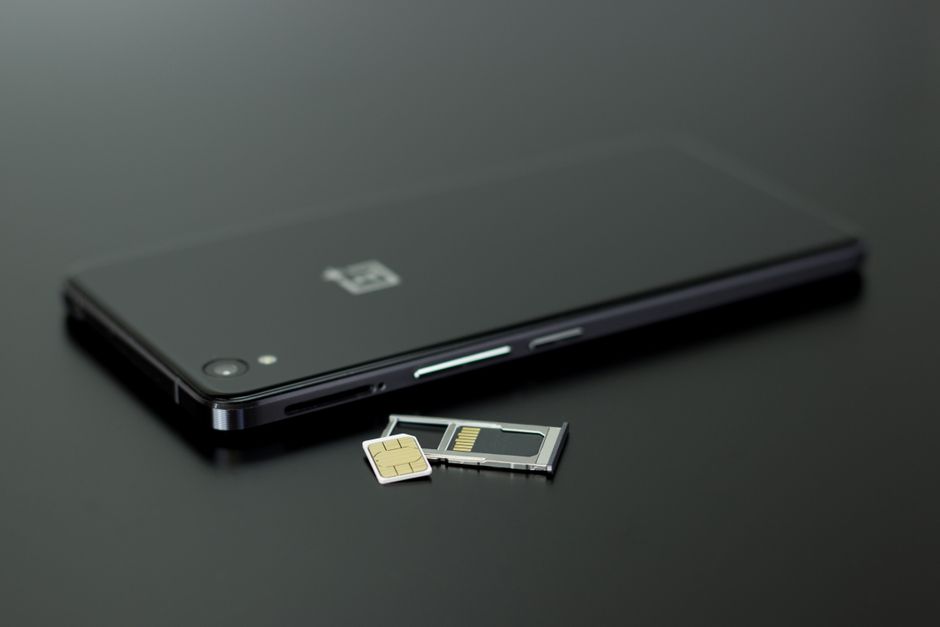手機旁擺著待安裝的 SIM 卡與取卡工具